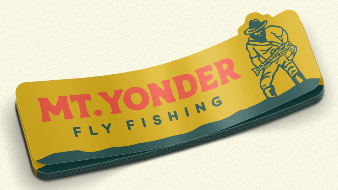 Small Horizontal Yellow sticker with red and green text. Sticker with the Mt. Yonder Fly Fishing Logo. A vintage looking mountain man with a big beard standing in water holding a big trout.