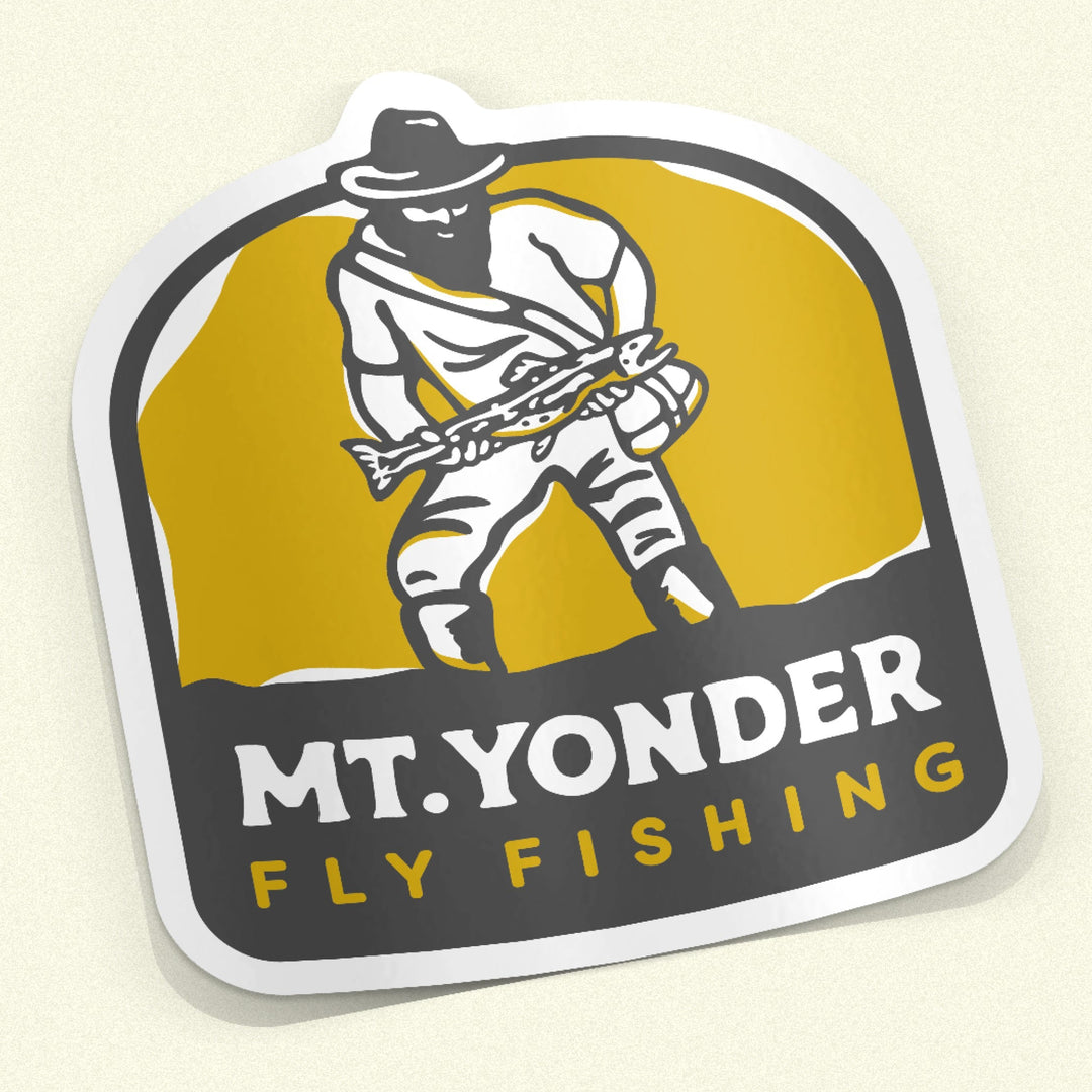 Oringal Logo Sticker with the Mt. Yonder Fly Fishing Logo. Yelow, Black and white. A vintage looking mountain man with a big beard standing in water holding a big trout.