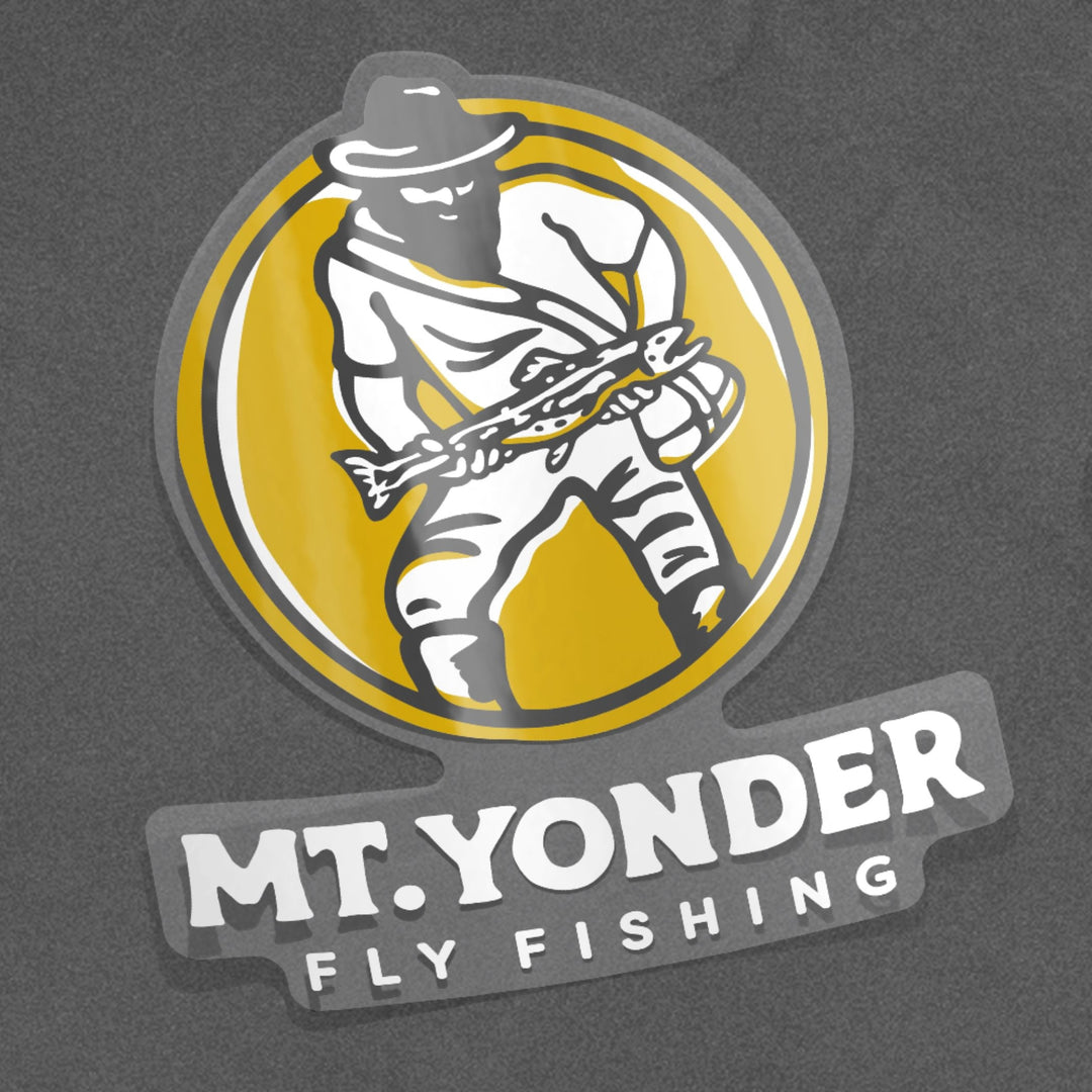 Clear yellow, black and white Sticker with the Mt. Yonder Fly Fishing Logo. A vintage looking mountain man with a big beard standing in water holding a big trout.